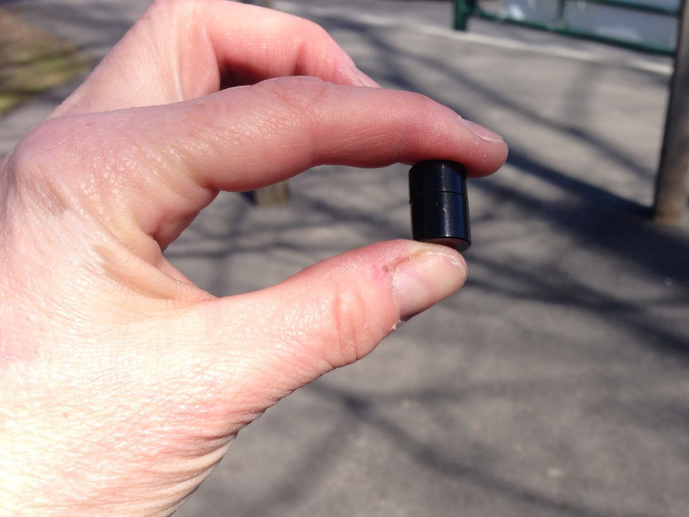 hand holding a small black tube